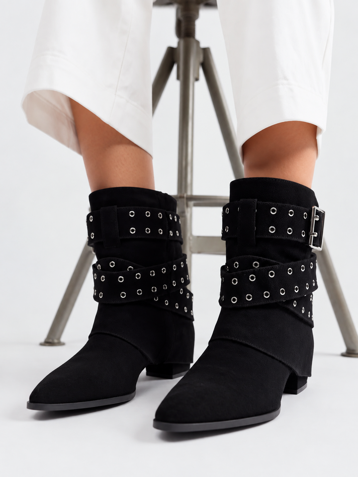 Black faux suede buckle strap slouch ankle boot – worn on model, front view of the pair