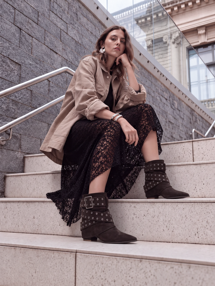 Brown faux suede buckle strap slouch ankle boot – full outfit on model on city steps
