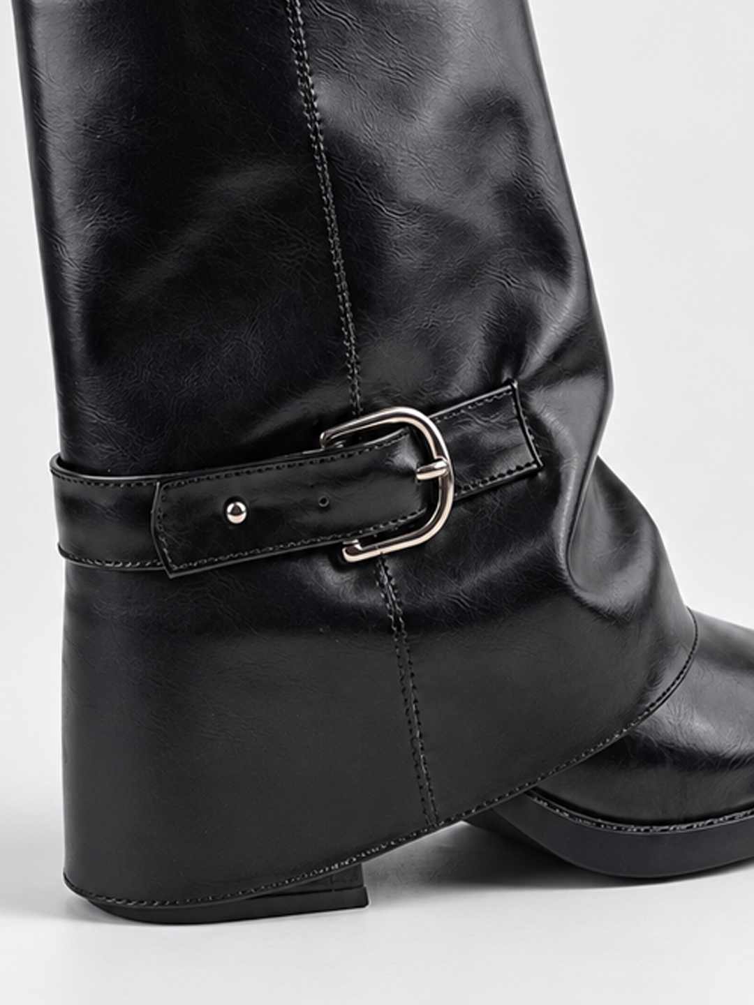Black fold-over buckle ankle boot faux leather – buckle strap and heel close-up