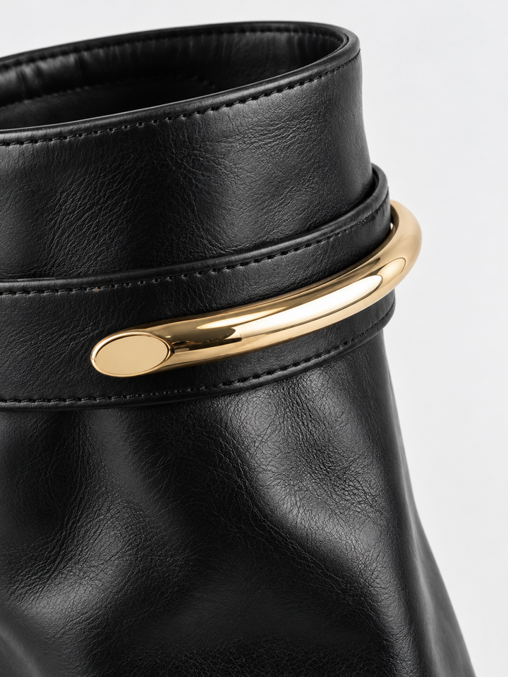Black fold-over gold bar ankle boot faux leather – gold-tone bar close-up