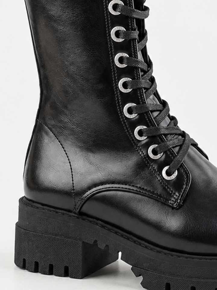 Black mid-calf lace-up combat boot faux leather – laces and lug sole close-up