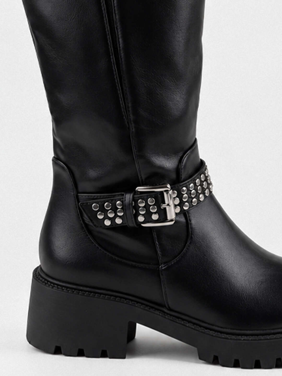 Black studded strap knee-high riding boot faux leather – studded ankle strap and heel close-up